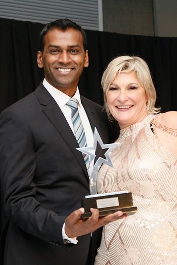 Lee Naik receiving the Pay it Forward Award from Laura Barker